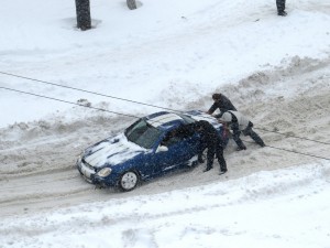 Men pushing car in snow